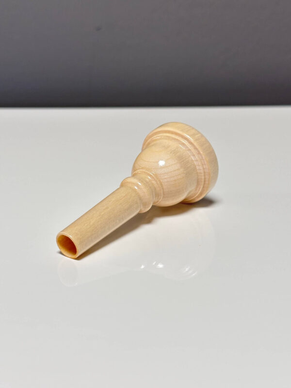 Natürliches Holzmundstück für ein Alphorn auf weißem Hintergrund, ideal für authentische Heimatalpenklänge.