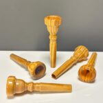 Handgefertigte Holzmundstücke für Alphörner, glänzend poliert. Ideal für klaren Klang bei Heimatklang Naturinstrumenten.