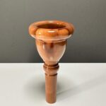 Hochwertiges Mundstück für Alphörner aus Holz, präsentiert auf einer neutralen Oberfläche.