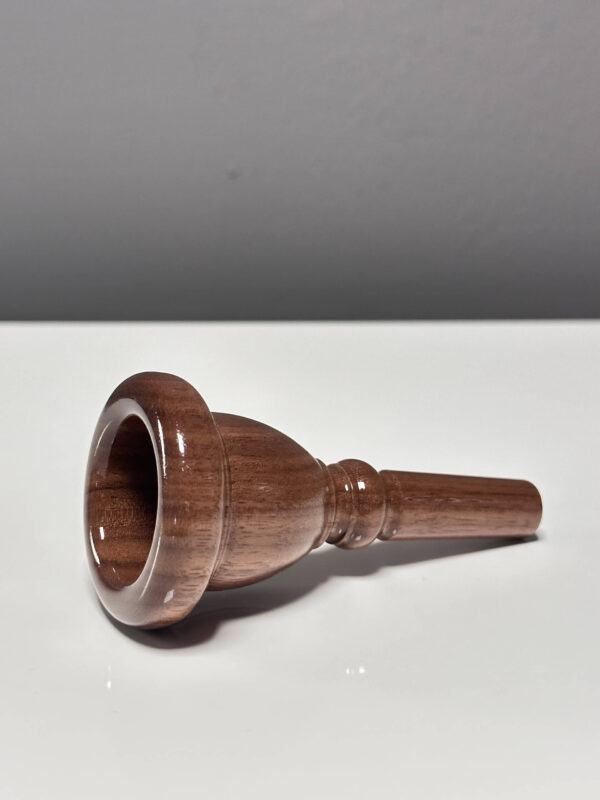 Hochwertiges Holzmundstück für Alphörner, elegant auf weißem Hintergrund präsentiert. Ideal für klare Heimatklänge.