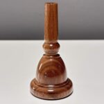 Holzmundstück aus edlem Holz, perfekt für Alphörner, präsentiert auf weißem Untergrund für höchsten Klanggenuss.