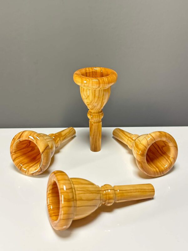 Vier hochwertige Holzmundstücke für Alphörner auf weißer Oberfläche, ideal für erstklassigen Klang bei Heimatklang Naturinstrumenten.