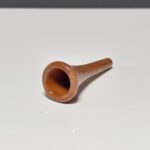 Holzmundstück für Alphorn, hochwertig und poliert, liegt auf einer weißen Oberfläche. Ideal für klassische Naturklänge.