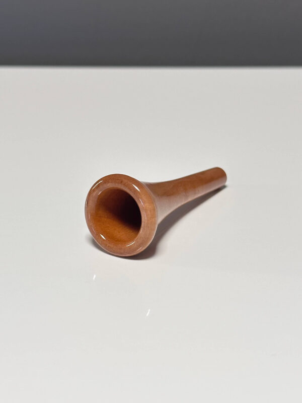 Holzmundstück für Alphorn, hochwertig und poliert, liegt auf einer weißen Oberfläche. Ideal für klassische Naturklänge.