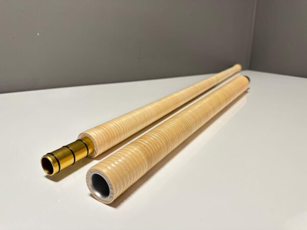 Zwei hochwertige Holzteile eines Alphorns mit goldener Verbindungsstelle, präsentiert auf einer weißen Fläche.