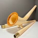 Alphorn mit hochwertigen Holzmundstücken, präsentiert auf weißem Hintergrund, ideal für traditionelle Klänge aus den Alpen.