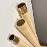 Drei hochwertige Holzmundstücke für Alphörner, stilvoll präsentiert, unterstreichen die Handwerkskunst von NATURINSTRUMENTE Heimatklang.