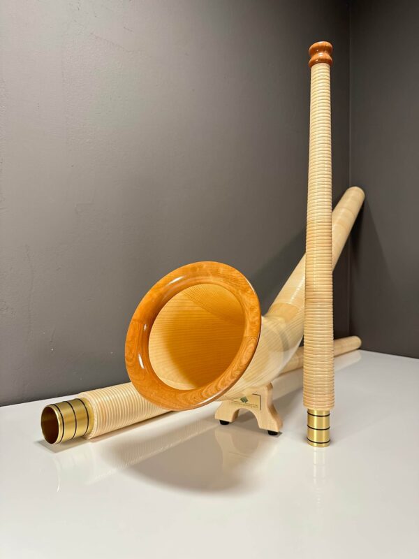 Alphorn und Holzmundstück auf einem Tisch, hochwertige Naturinstrumente von Heimatklang. Perfekt für traditionelle Musik.