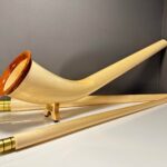 Hochwertiges Alphorn mit goldenen Details und hölzernem Mundstück, präsentiert von NATURINSTRUMENTE Heimatklang.