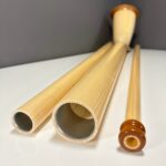 Alphorn mit hochwertigen Holzmundstücken auf weißem Hintergrund, präsentiert von NATURINSTRUMENTE Heimatklang.