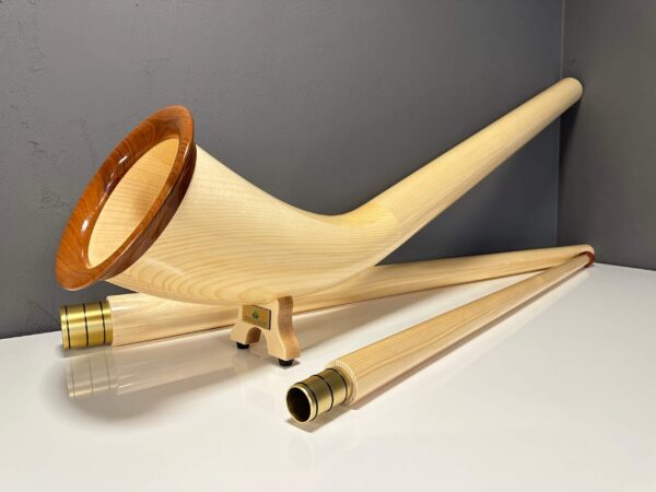Hochwertiges Alphorn mit edlen Holzmundstücken, gezeigt in stilvollem Ambiente, betont die Handwerkskunst von Heimatklang.
