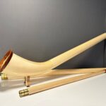 Hochwertiges Alphorn mit Holzmundstück auf weißer Fläche, präsentiert von Heimatklang für exzellenten Naturklang.