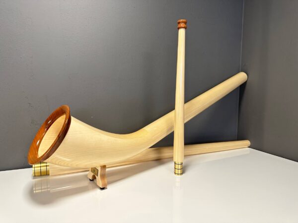 Alpenhorn aus hellem Holz mit elegantem Design, präsentiert auf einem Tisch; Teil der NATURINSTRUMENTE Heimatklang Kollektion.