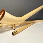 Handgefertigtes Alphorn aus hellem Holz mit abnehmbaren Teilen, präsentiert von NATURINSTRUMENTE Heimatklang.