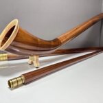 Edles Alphorn aus Holz mit präziser Verarbeitung, präsentiert auf einem weißen Hintergrund, betont Naturinstrumente Heimatklang.