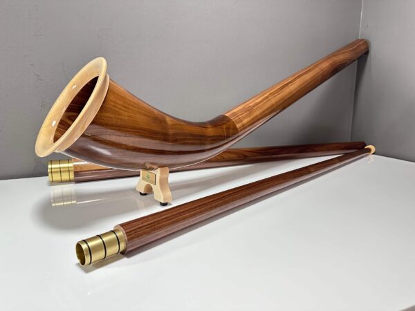 Edles Alphorn aus Holz mit präziser Verarbeitung, präsentiert auf einem weißen Hintergrund, betont Naturinstrumente Heimatklang.