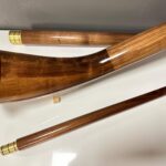 Glänzende Alphörner aus edlem Holz auf weißem Hintergrund, gefertigt von Heimatklang für Klangqualität und Tradition.