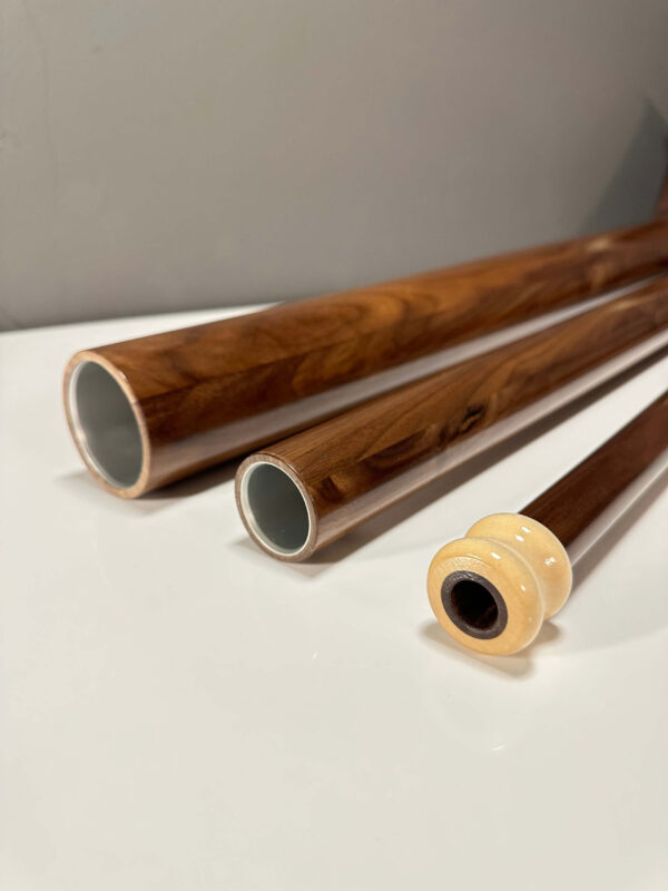 Alphornrohre und Mundstück aus edlem Holz auf weißem Hintergrund, hochwertige Handwerkskunst für Naturinstrumente Liebhaber.