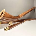 Alpenhorn aus edlem Holz mit Mundstück auf weißem Hintergrund, präsentiert von NATURINSTRUMENTE Heimatklang.