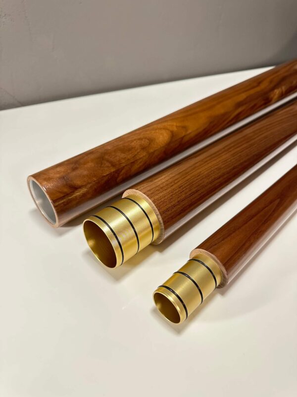 Hochwertige Holzmundstücke für Alphörner, elegant auf einem weißen Hintergrund präsentiert, betonen traditionelle Handwerkskunst.