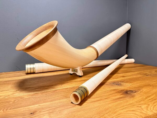 Hochwertiges Alphorn mit Holzmundstück auf Holztisch, perfekter Klang für Naturinstrumente-Enthusiasten bei Heimatklang.