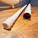 Alphorn und feine Holzmundstücke auf Tisch, detailreiche Handwerkskunst für NATURINSTRUMENTE Heimatklang.