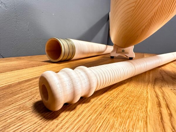 Hochwertige Alphorn-Mundstücke aus Holz auf einem Tisch, zeigen Handwerkskunst und Tradition der Heimatklang Naturinstrumente.