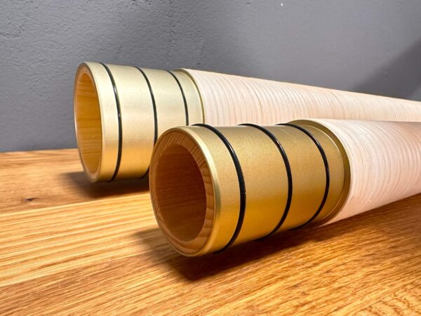 Nahaufnahme von zwei hochwertigen Alphorn-Mundstücken aus Holz auf Holztisch, ideal für authentischen Heimatklang der Alpen.