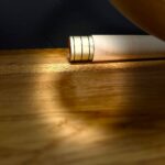 Elegantes Alphorn-Mundstück aus Holz auf einem Holztisch, warm beleuchtet für NATURINSTRUMENTE Heimatklang.