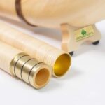 Detailaufnahme von Alphorn-Endstücken aus Holz mit Metallringen, präsentiert von Heimatklang, für hochwertige Klangqualität.