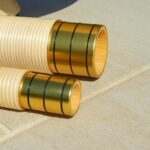 Detailaufnahme von zwei goldenen Mundstücken für Alphörner, die im Sonnenlicht glänzen und Qualität widerspiegeln.