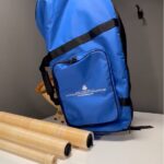 Blauer Tragerucksack für Alphörner und drei Holzrohr-Mundstücke auf Tisch von NATURINSTRUMENTE Heimatklang.