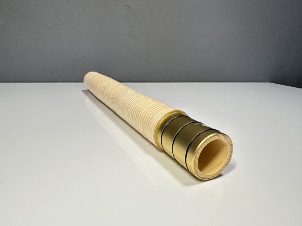 Handgefertigtes Alpenhorn-Mundstück aus Holz mit goldenen Details auf einem weißen Tisch, präsentiert von NATURINSTRUMENTE Heimatklang.