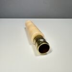 Detailaufnahme eines hochwertigen Holzmundstücks für ein Alphorn, präsentiert auf einer grauen Fläche.