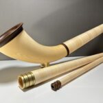 Hochwertiges Alphorn mit separatem Holzmundstück, präsentiert auf einem Tisch, ideal für Naturinstrumente-Enthusiasten.