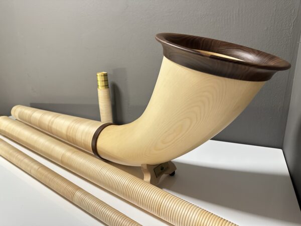 Alphorn mit Holzmundstück und Segmenten auf weißer Oberfläche, präsentiert von NATURINSTRUMENTE Heimatklang.