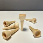 Holzmundstücke für Alphörner in Nahaufnahme auf weißem Untergrund, ideal für Naturinstrumente-Enthusiasten.