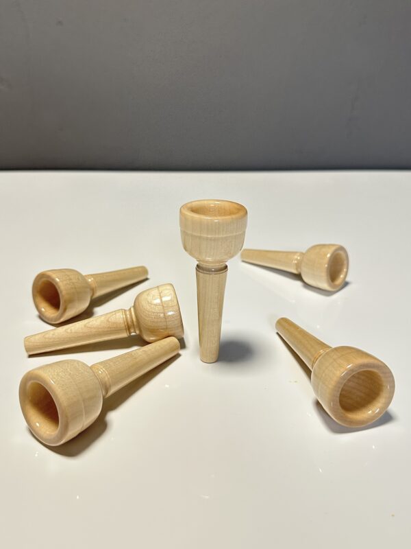 Holzmundstücke für Alphörner in Nahaufnahme auf weißem Untergrund, ideal für Naturinstrumente-Enthusiasten.