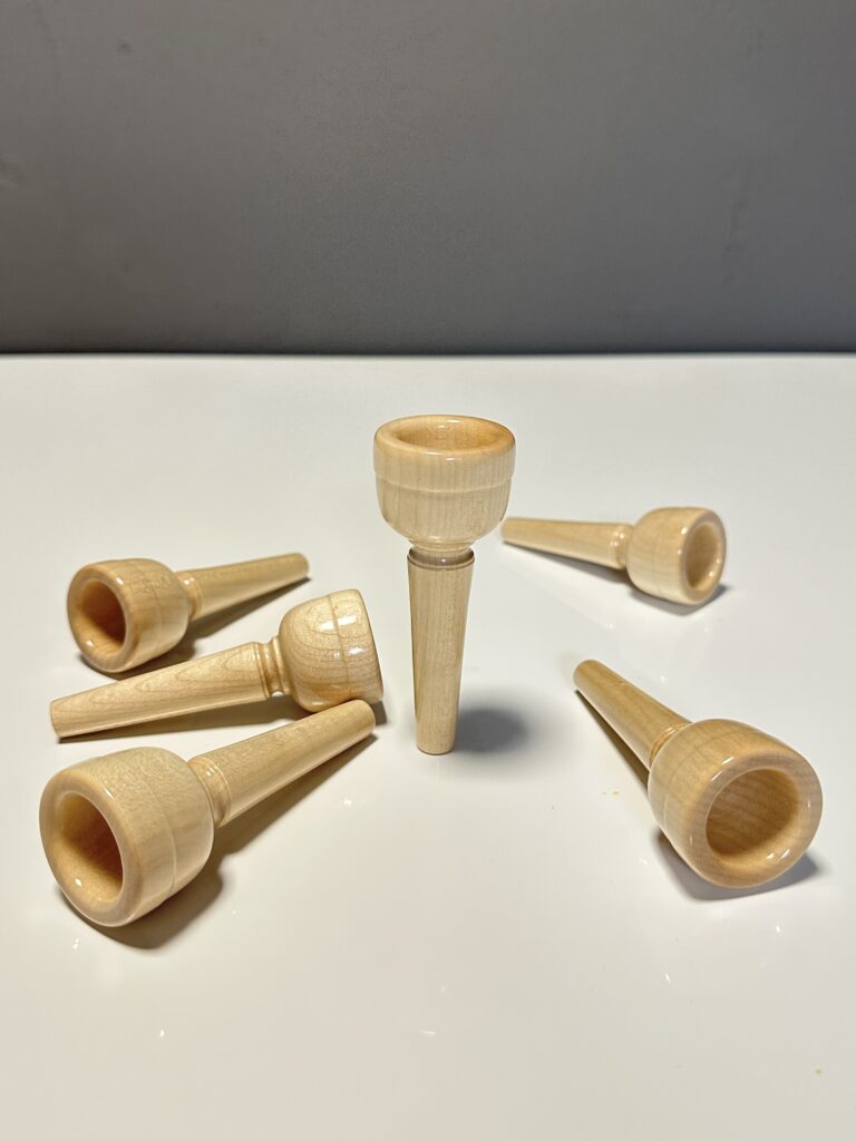 Wooden mouthpieces for alphorns in close-up on a white background, ideal for natural instrument enthusiasts.