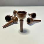 Hochwertige Holzmundstücke für Alphörner, elegant arrangiert auf weißem Hintergrund, repräsentieren exzellente Handwerkskunst.