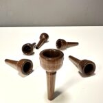 Hochwertige Holzmundstücke für Alphörner liegen auf weißem Hintergrund, perfekt für Naturinstrumente-Enthusiasten.